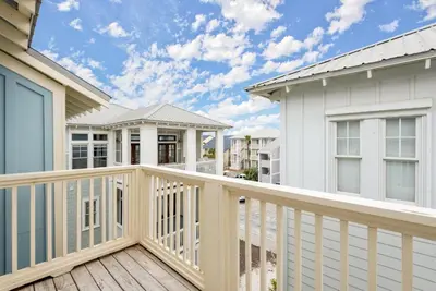 a deck with a white house and a house at Blue Heaven in Santa Rosa Beach