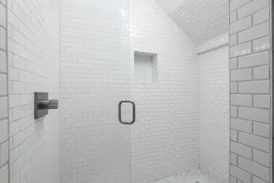 a white tiled shower with a glass door at Blue Heaven in Santa Rosa Beach