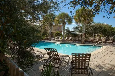 two chairs sitting next to a swimming pool at Blue Heaven in Santa Rosa Beach