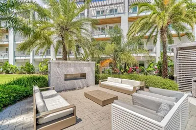 a patio with couches and a fireplace in front of a building at Cabanas and Sunsets in Inlet Beach