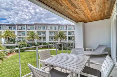 a balcony with a table and chairs and a building at Cabanas and Sunsets in Inlet Beach