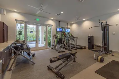a gym with several treadmills and machines in a room at Cabanas and Sunsets in Inlet Beach