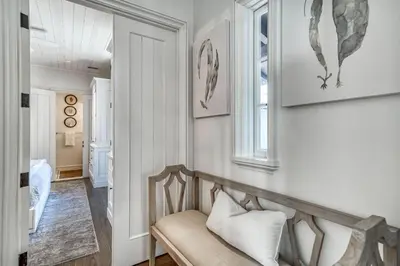 a living room with a bench and a window at Rosemary Renaissance in Rosemary Beach