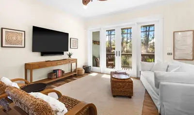 a living room with a white couch and a flat screen tv at Family Tides in Santa Rosa Beach