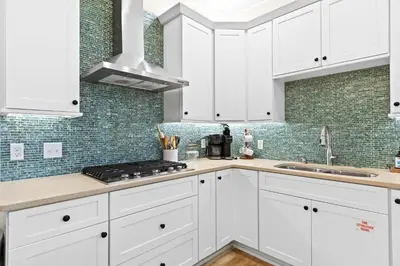 a white kitchen with white cabinets and a sink at Family Tides in Santa Rosa Beach