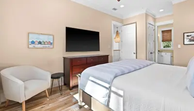 a bedroom with a bed and a chair and a television at Family Tides in Santa Rosa Beach