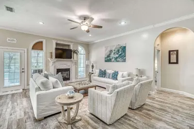a living room with white furniture and a fireplace at Sandy's Seacrest in Inlet Beach