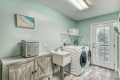 a laundry room with a washing machine and a sink at Sandy's Seacrest in Inlet Beach