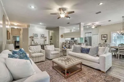 a living room with white furniture and a dining room at Sandy's Seacrest in Inlet Beach