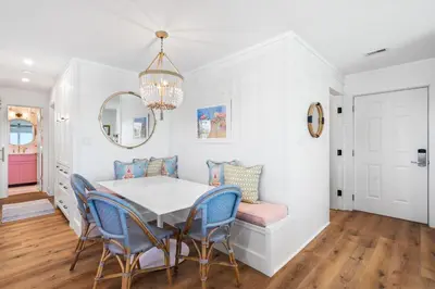 a dining room with a white table and blue chairs at After Dune Delight in Santa Rosa Beach