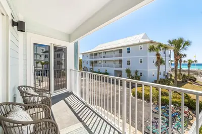 a balcony with chairs and a view of a building at After Dune Delight in Santa Rosa Beach