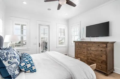 a bedroom with a bed and a flat screen tv at Sunshine and Fresh Air in Inlet Beach