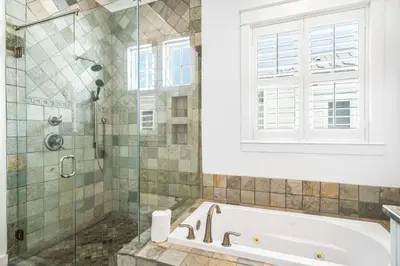 a bathroom with a tub and a glass shower at Sunshine and Fresh Air in Inlet Beach