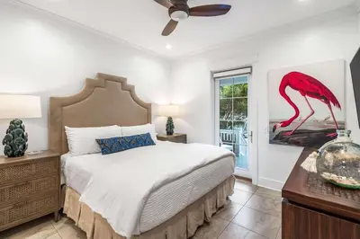 a bedroom with a bed with a red flamingo painting on the wall at Sunshine and Fresh Air in Inlet Beach