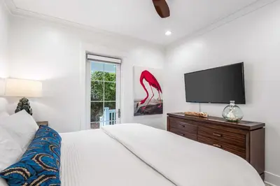 a bedroom with a bed and a flat screen tv at Sunshine and Fresh Air in Inlet Beach