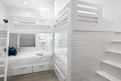 a white bedroom with a bunk bed in it at Sunshine and Fresh Air in Inlet Beach