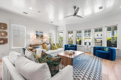 a living room with white furniture and blue chairs at Sunshine and Fresh Air in Inlet Beach