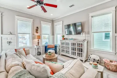 a living room with a couch and a tv at Daydream Believer (Seagrove) in Santa Rosa Beach