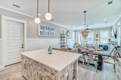 a kitchen and dining room with a table and chairs at Daydream Believer (Seagrove) in Santa Rosa Beach