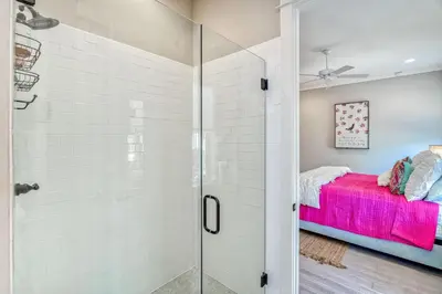 a shower with a glass door leading to a bedroom at Daydream Believer (Seagrove) in Santa Rosa Beach