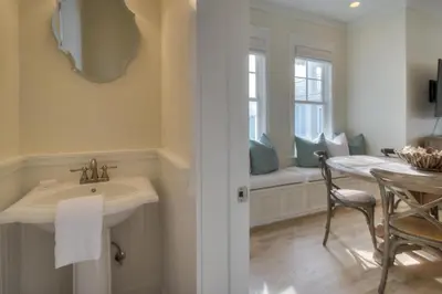 a bathroom with a sink and a table and a window at Seas the Day in Santa Rosa Beach