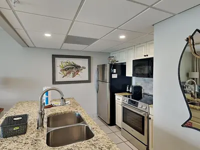 a kitchen with a sink and a stainless steel refrigerator at Edgewater Tower Iii 1109 in Panama City Beach