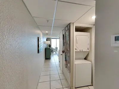 a hallway with a laundry room with a washer and dryer at Edgewater Tower Iii 1109 in Panama City Beach