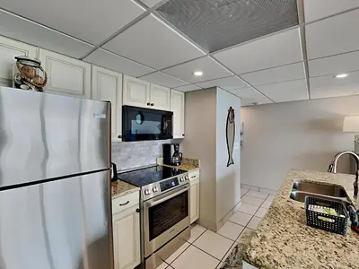 a kitchen with a stainless steel refrigerator and a microwave at Edgewater Tower Iii 1109 in Panama City Beach