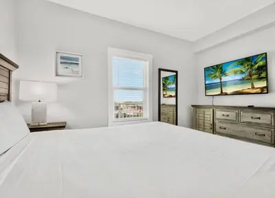 a white bedroom with a large bed and a window at Spectacular 1BD Resort Condo! Amazing Gulf Views! Free Beach Chairs! by Dolce Vita Getaways PCB in Panama City Beach