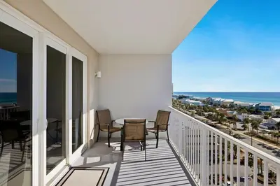 a balcony with a table and chairs and the ocean at Spectacular 1BD Resort Condo! Amazing Gulf Views! Free Beach Chairs! by Dolce Vita Getaways PCB in Panama City Beach