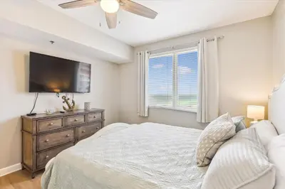 a bedroom with a bed and a flat screen tv at Shores of Panama 2028 - Luxurious Gulf-Front 3 Bedroom 3 Bath Sleeps 10 condo in Panama City Beach