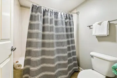 a bathroom with a shower curtain and a toilet at Shores of Panama 2028 - Luxurious Gulf-Front 3 Bedroom 3 Bath Sleeps 10 condo in Panama City Beach