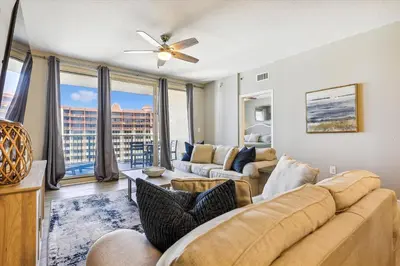 a living room with a couch and a large window at Shores of Panama 2028 - Luxurious Gulf-Front 3 Bedroom 3 Bath Sleeps 10 condo in Panama City Beach