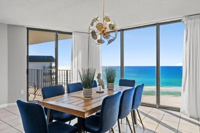 a dining room with a table and chairs and the ocean at Edgewater Beach Resort - Tower I #1201 in Panama City Beach