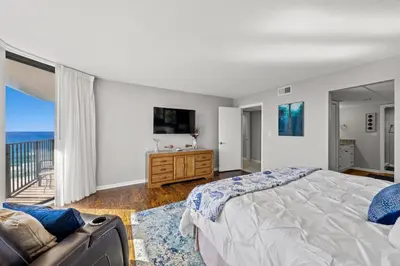 a bedroom with a bed and a view of the ocean at Edgewater Beach Resort - Tower I #1201 in Panama City Beach