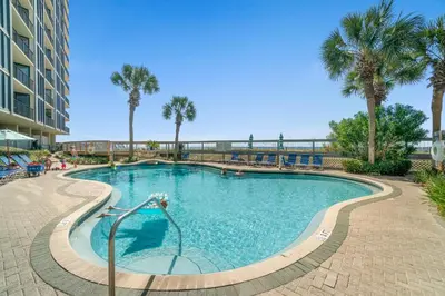 a swimming pool with palm trees in a resort at Edgewater Beach Resort - Tower I #1201 in Panama City Beach