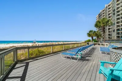 a deck with blue chairs and the beach at Edgewater Beach Resort - Tower I #1201 in Panama City Beach