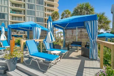 a deck with blue chairs and umbrellas at Edgewater Beach Resort - Tower I #1201 in Panama City Beach