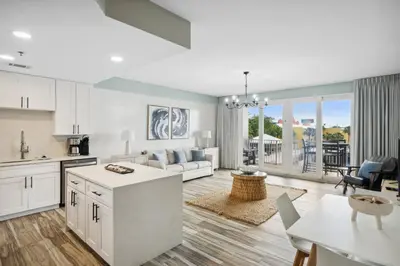 a kitchen and living room with a couch and a table at Laketown Wharf #137 by Nautical Properties in Panama City Beach