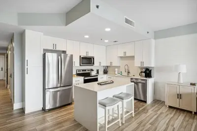 a kitchen with white cabinets and stainless steel appliances at Laketown Wharf #137 by Nautical Properties in Panama City Beach