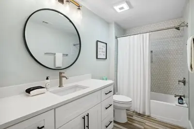 a white bathroom with a sink and a mirror at Laketown Wharf #137 by Nautical Properties in Panama City Beach