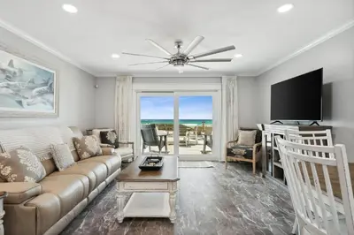 a living room with a couch and a flat screen tv at Dolphin View at 8629 Surf Drive by Nautical Properties in Panama City Beach