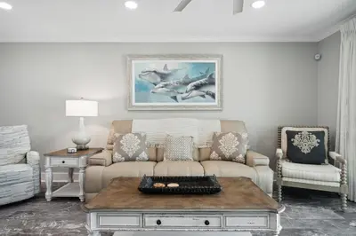 a living room with a couch and a table at Dolphin View at 8629 Surf Drive by Nautical Properties in Panama City Beach