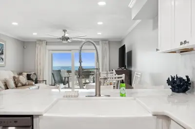 a kitchen with a sink and a living room at Dolphin View at 8629 Surf Drive by Nautical Properties in Panama City Beach