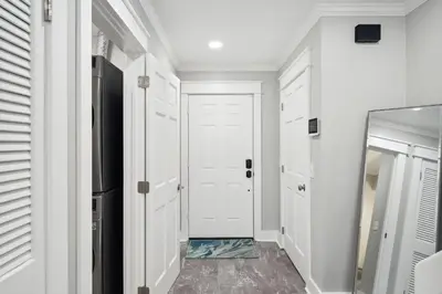 a hallway with a white door and a mirror at Dolphin View at 8629 Surf Drive by Nautical Properties in Panama City Beach