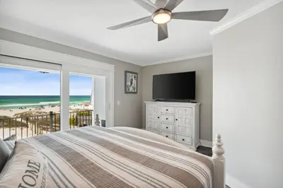 a bedroom with a bed and a flat screen tv at Dolphin View at 8629 Surf Drive by Nautical Properties in Panama City Beach