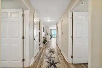 a hallway with white doors and a rug on the floor at Blissful Sunset at Laketown Wharf #1312 by Nautical Properties in Panama City Beach