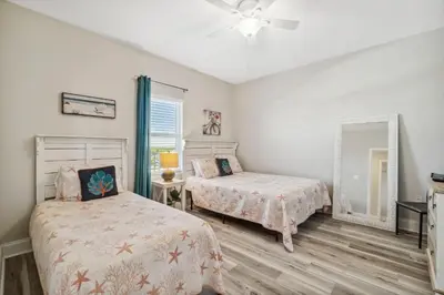 a bedroom with two beds and a mirror at Blissful Sunset at Laketown Wharf #1312 by Nautical Properties in Panama City Beach