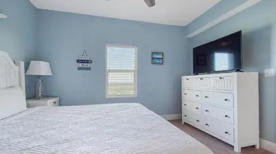 a bedroom with a white bed and a flat screen tv at Laketown Wharf #1319 by Nautical Properties in Panama City Beach