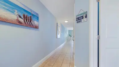 a hallway with a tile floor and a painting on the wall at Laketown Wharf #1319 by Nautical Properties in Panama City Beach